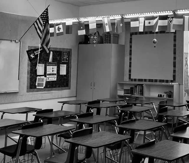 An empty classroom, desks and flags